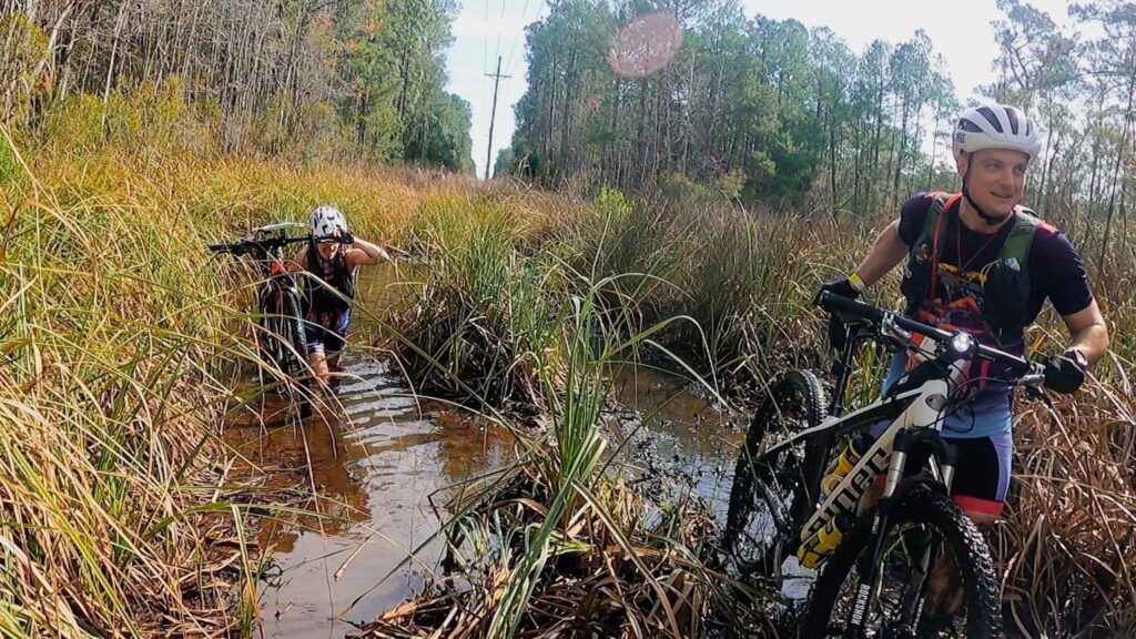 Heather Hart and Brian Killory of Team HSEC carry their bikes through knee deep water and mud during the Palmetto Swamp Fox Adventure Race