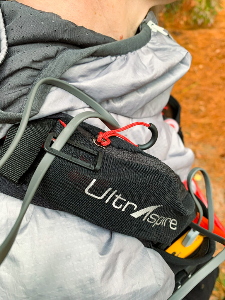 BioLite HeadLamp 800 Pro Run Forever Cable clipped to a hydration pack on an ultra runner's shoulder