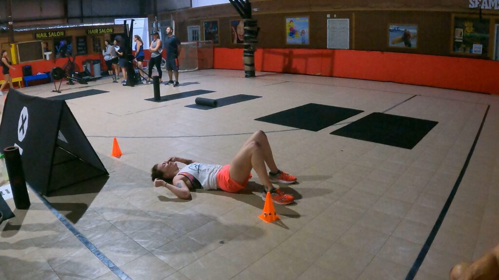 Heather Hart lies on the floor exhausted after a Spartan DEKA Strong event
