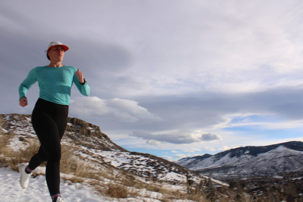Woman running down a snow covered hill