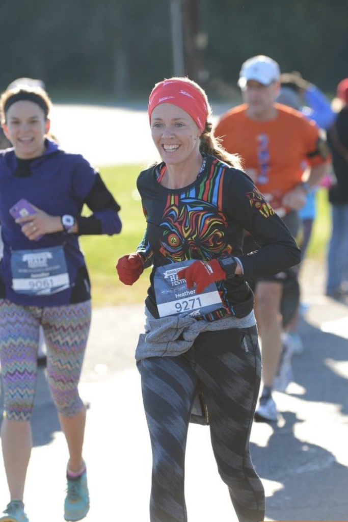 Heather Hart runs in a half marathon road race surrounded by other runners