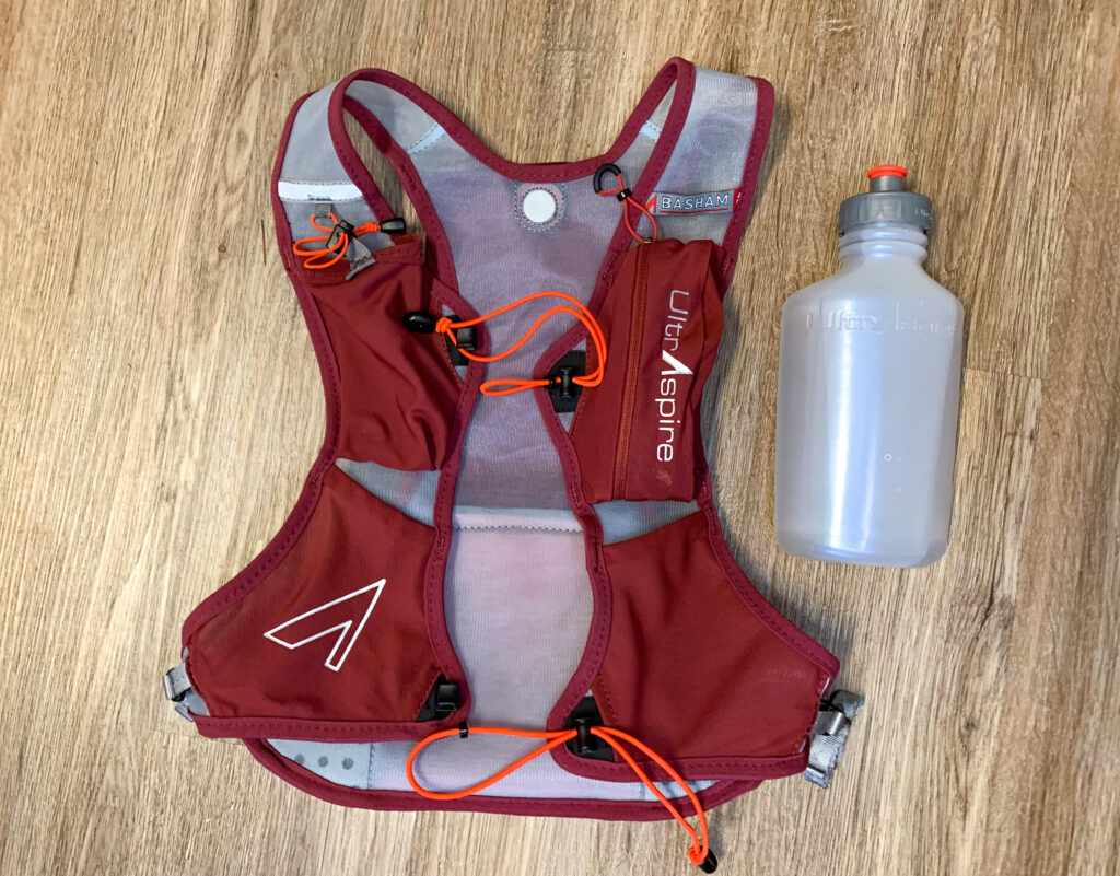 Front view of the UltrAspire Basham Race Vest with the 550 mL UltraFlask bottle