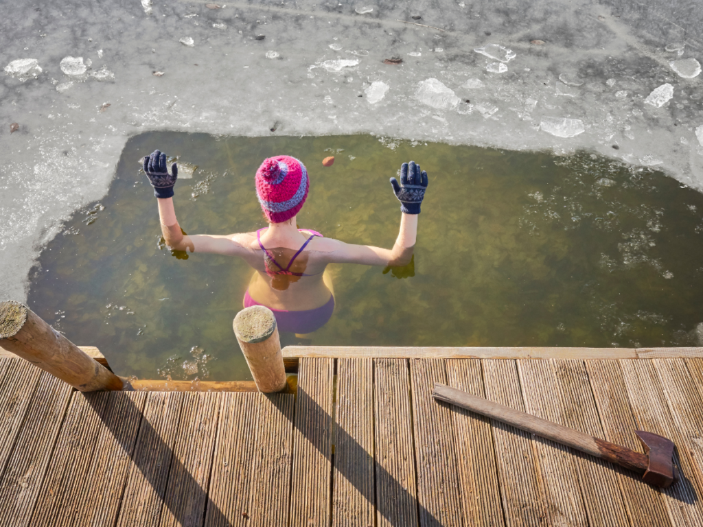 Woman standing in an ice covered pond as a means of post workout recovery