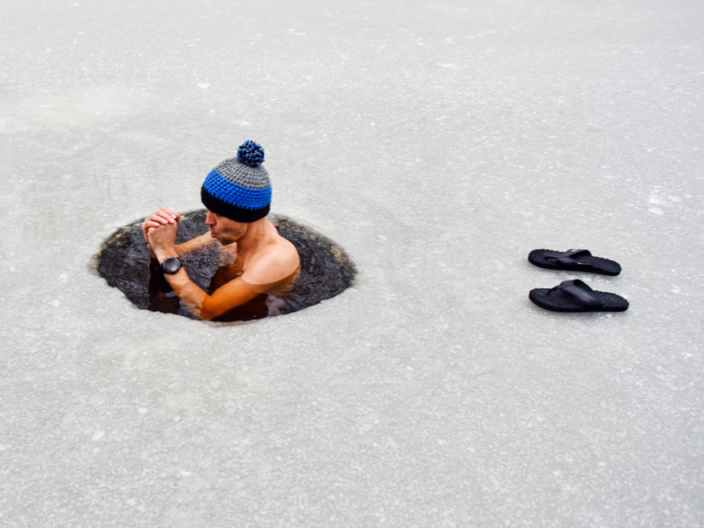 Man taking an ice bath after running in a lake 
