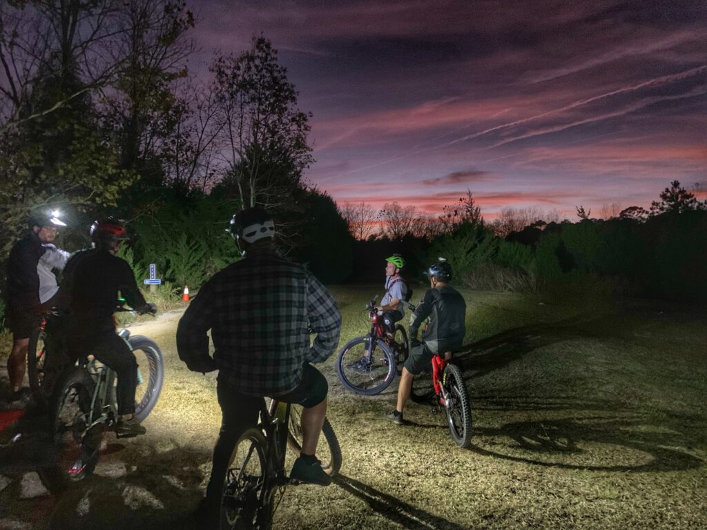 Mountain bikers resting during a group ride at sunset