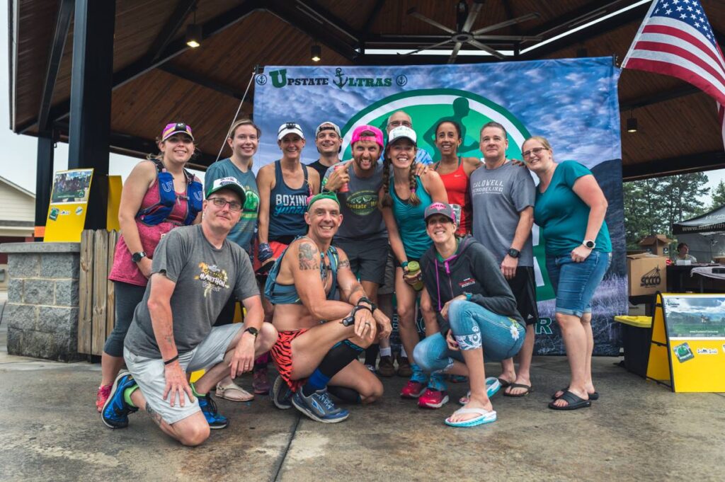 Group of trail runners posing for a photo before the start of an ultramarathon 