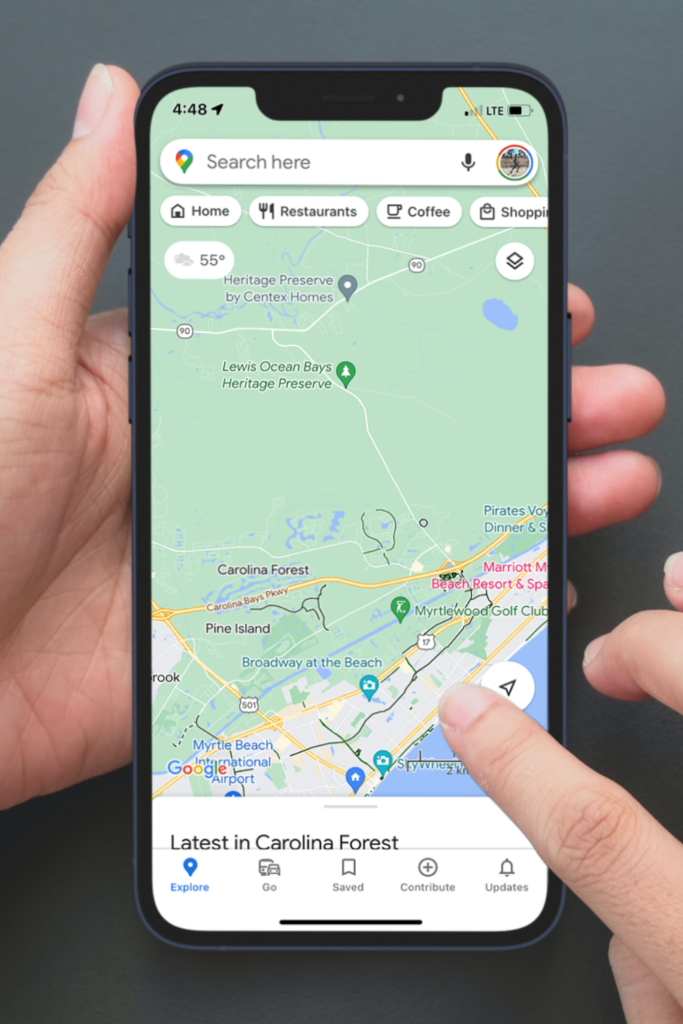 Image of a cell phone with Google Maps open looking for running trails near me 