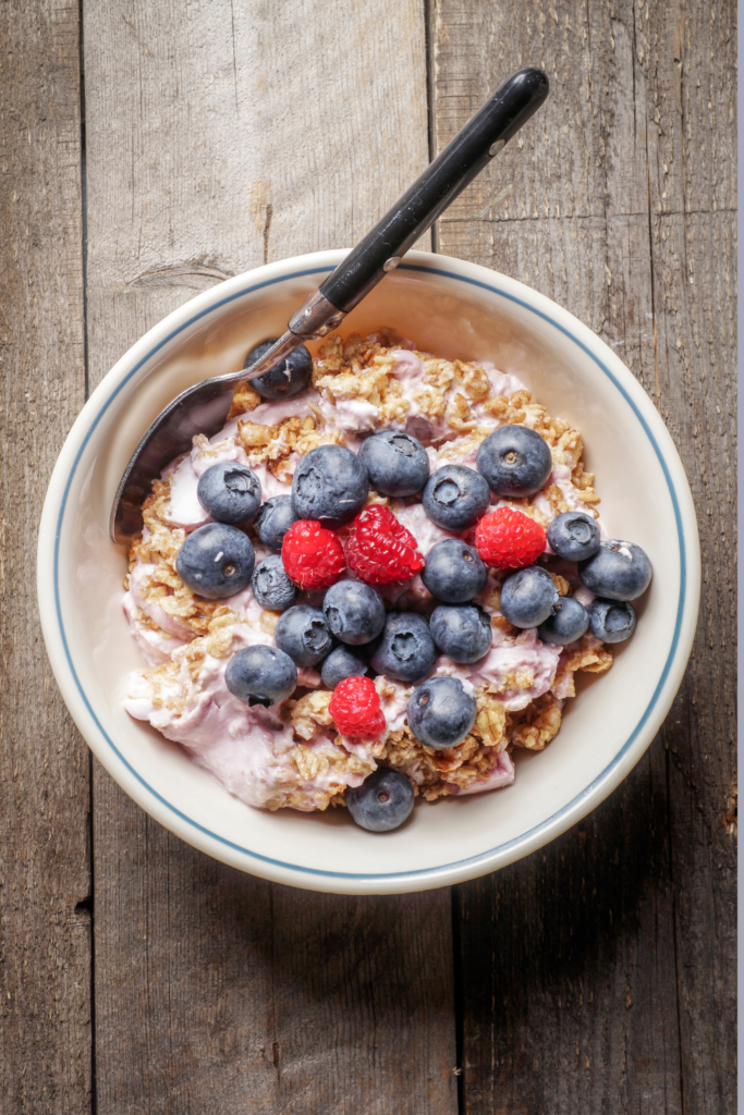 Oatmeal mixed with yogurt topped with fresh berries in a breakfast bowl