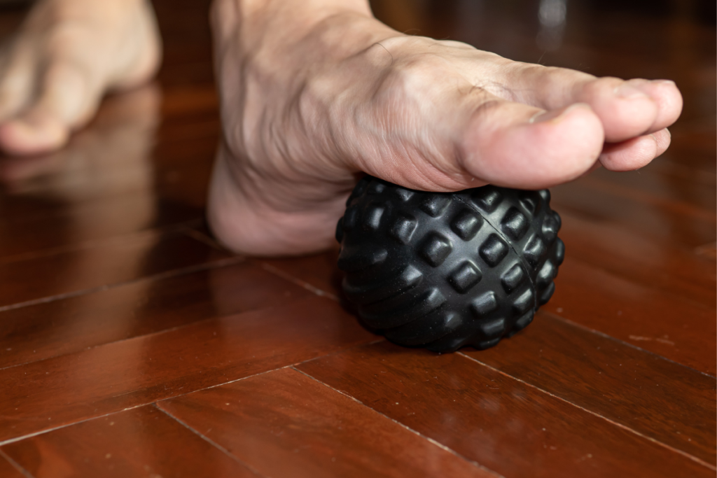 image of a runner's foot rolling on a massage ball to help alleviate plantar fasciitis pain