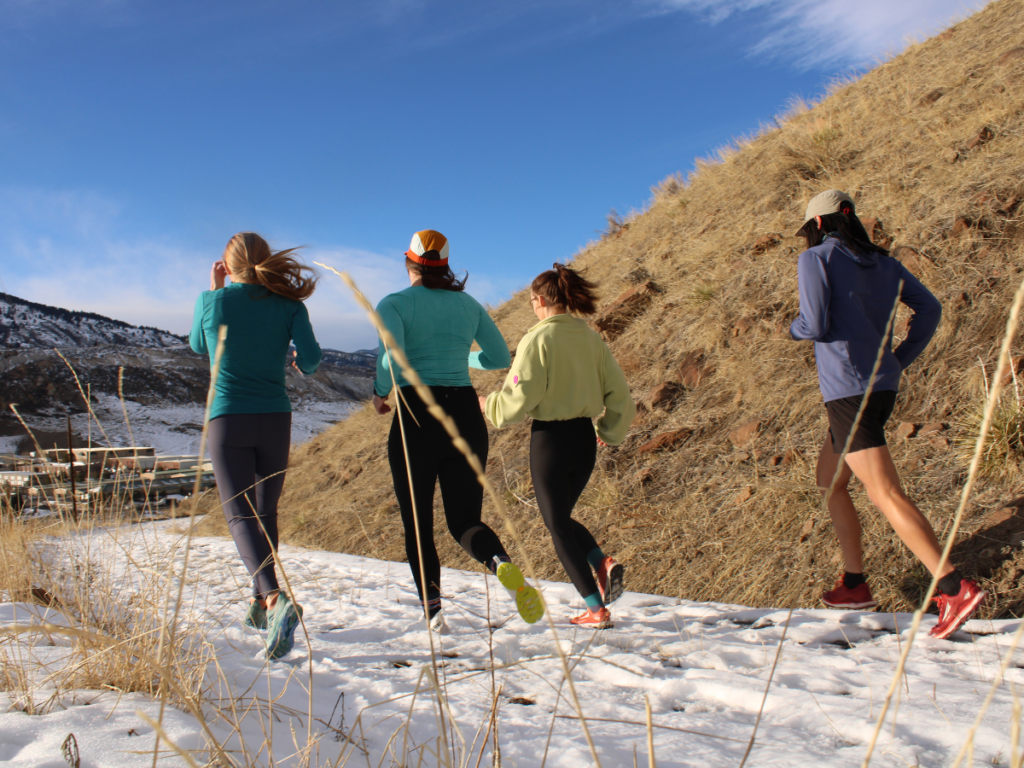 A group of runners downhill running on a snowy path