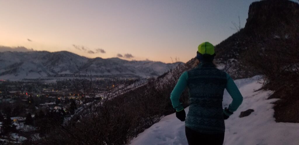 Image of a runner on a winter trail run as the sun begins to set