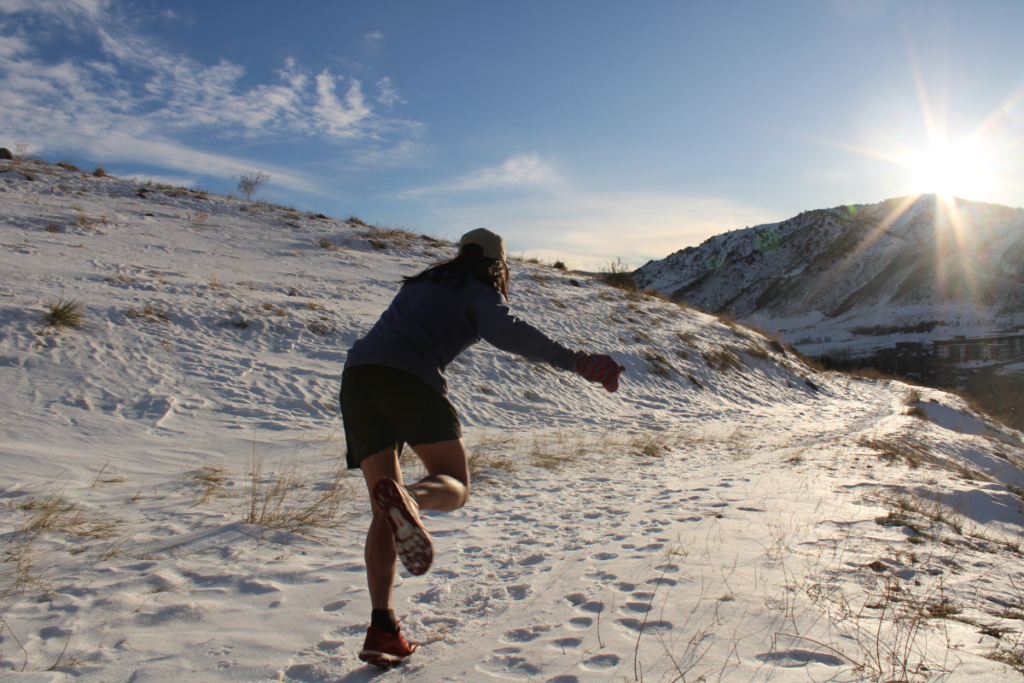 Runner slipping on the snow during a winter trail run